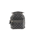 Black Valentino Garavani Rockstud Spike mini backpack in quilted leather with pyramid studs, top handle, and front zip pocket.