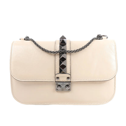 Beige handbag with a decorative chain and clasp on a white background