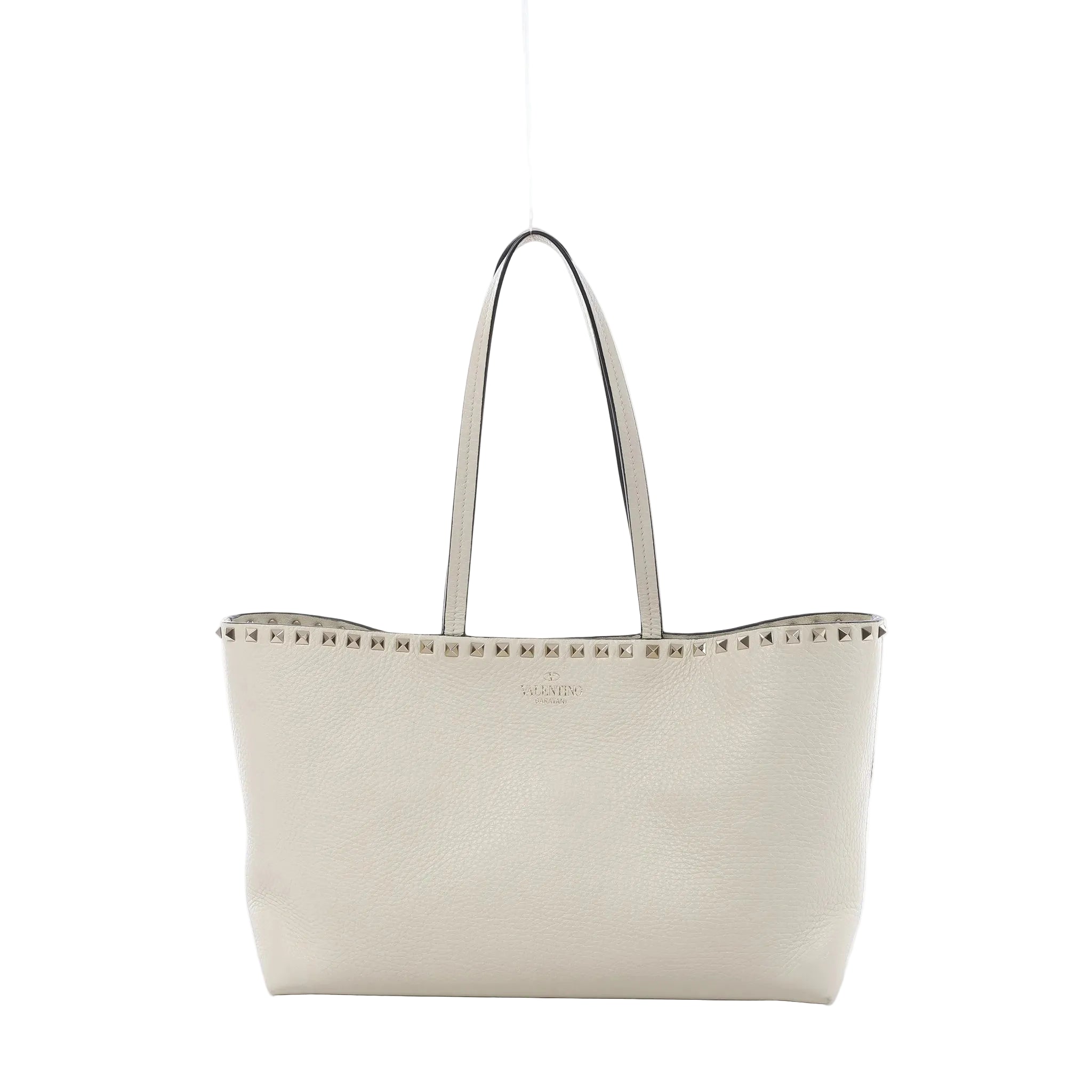 Valentino Garavani Rockstud ecru grained leather shoulder bag with slim shoulder straps, silver-tone stud trim, and structured open-top silhouette on white background.