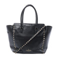 Valentino Garavani black leather handbag with pyramid stud trim, two top handles, detachable studded shoulder strap and gold logo.