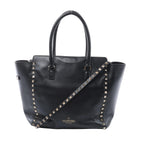 Valentino Garavani black leather handbag with pyramid stud trim, two top handles, detachable studded shoulder strap and gold logo.