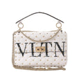 White Valentino Rockstud Spike VLTN quilted leather shoulder bag with gold stud detailing, gold chain strap, top handle, and turn-lock closure on white background