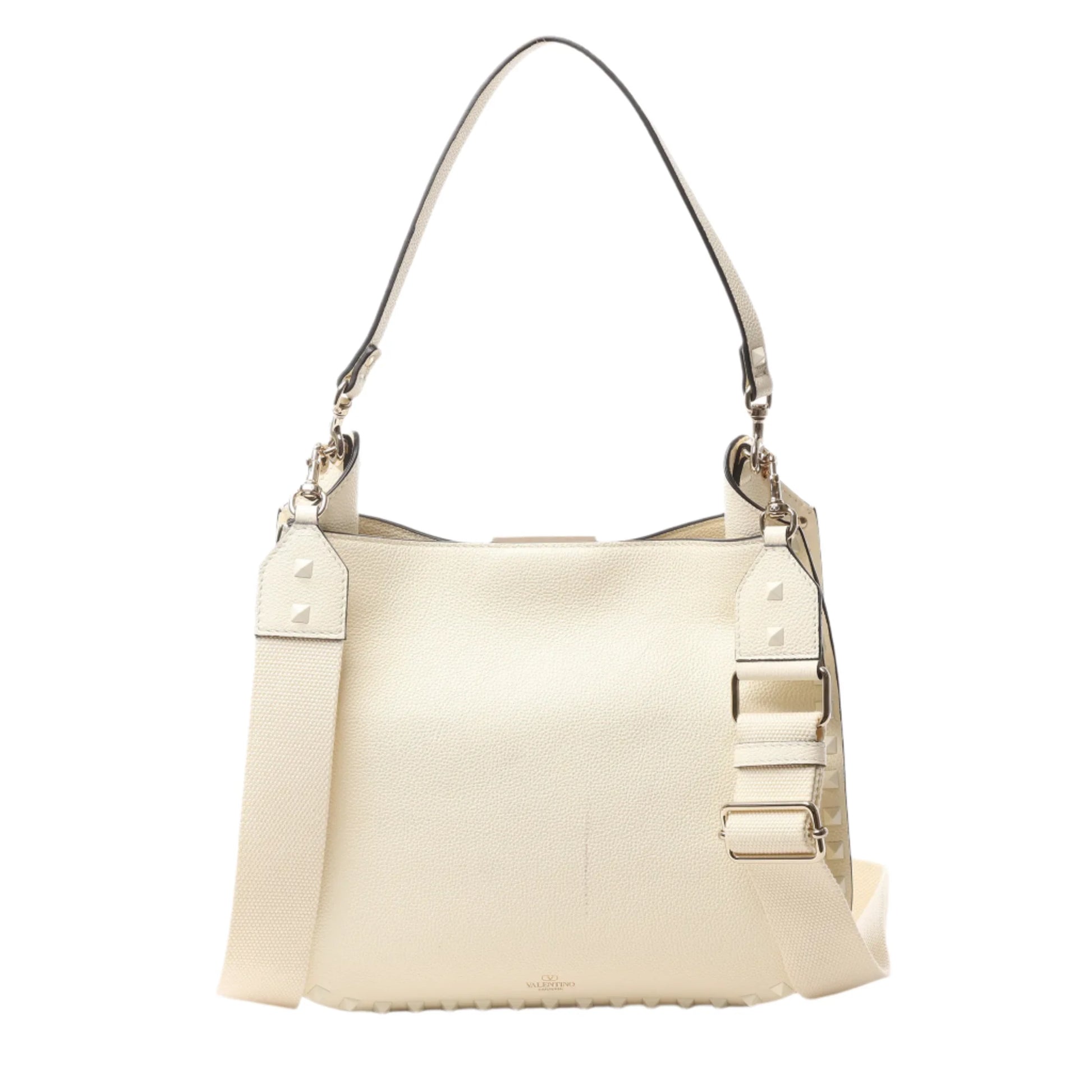 Front view of Valentino Garavani Rockstud Leather Shoulder Bag in ecru grained leather with tonal pyramid stud trim, top handle, and wide adjustable shoulder strap, displayed against a white background.