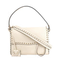 Valentino Garavani Rockstud 2Way Handbag in beige leather featuring signature gold-tone pyramid studs along the edges and strap, with a top handle, detachable shoulder strap, and matching studded coin pouch.