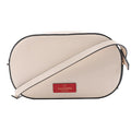 Valentino Garavani crossbody bag in pale pink leather with black edge trim, slim shoulder strap and red logo patch on the front.