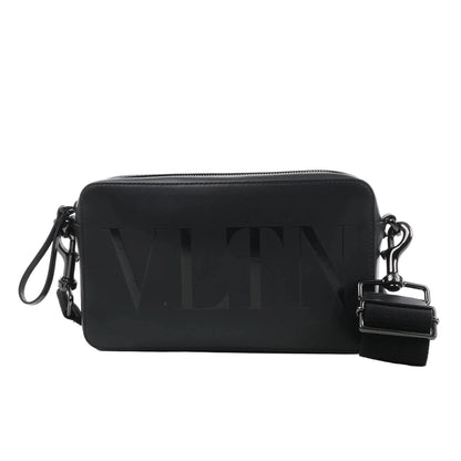 Valentino Garavani VLTN black leather shoulder bag with embossed logo, zip closure, detachable strap, and rectangular structured design against a white background.