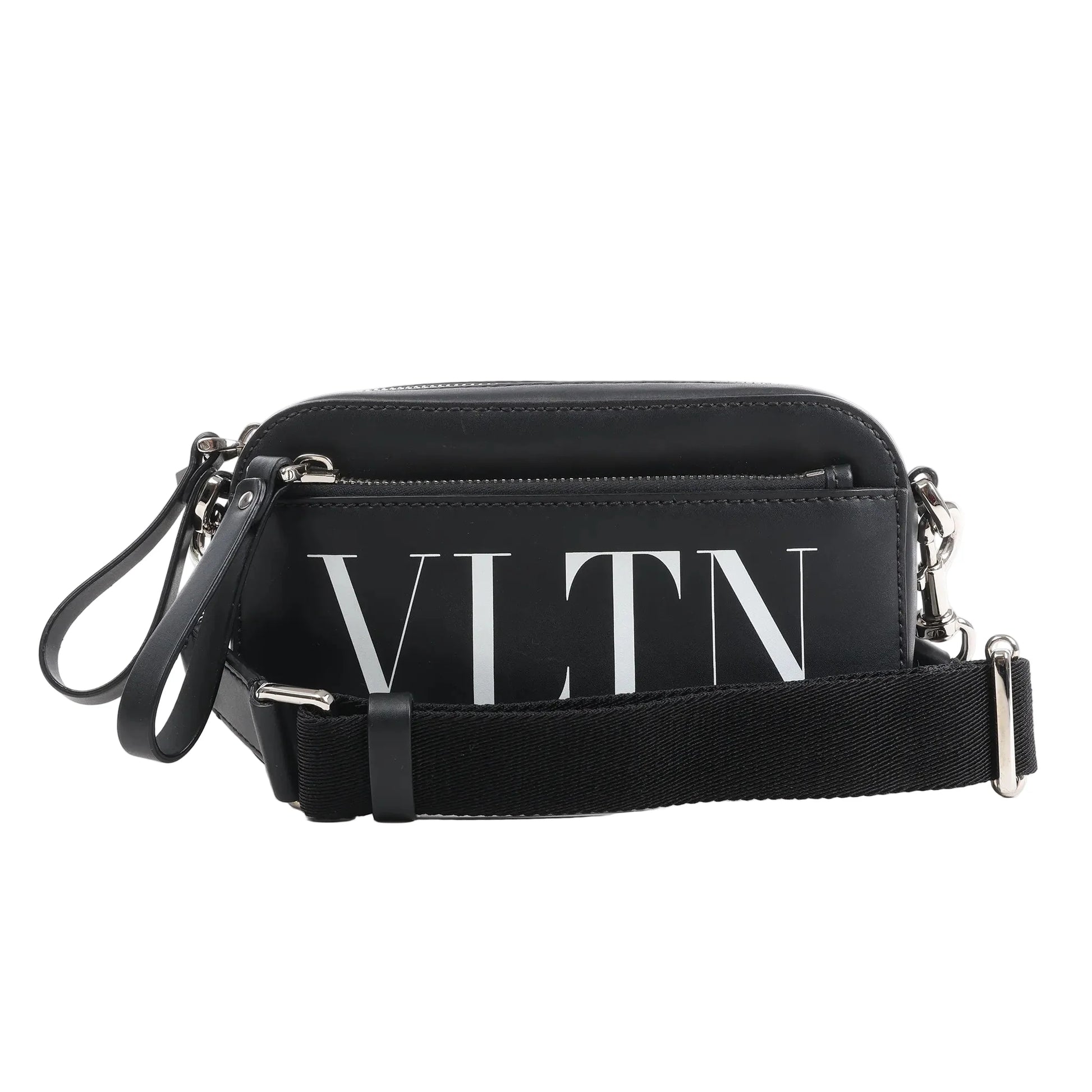 Front view of the Valentino Garavani VLTN Leather Shoulder Bag in black, featuring smooth leather exterior, bold white VLTN logo print, front zip pocket, detachable black fabric strap, and silver-tone hardware, displayed against a white background.