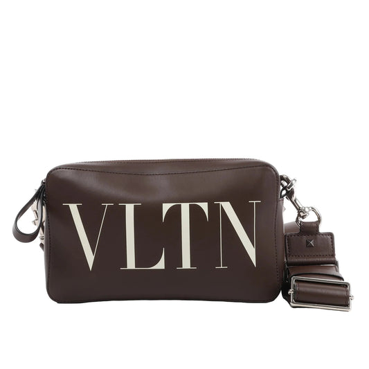 Valentino Garavani VLTN shoulder bag in smooth brown leather with large white logo print, detachable strap, zip closure, and rectangular structured shape against a white background.