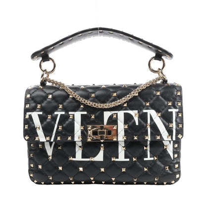 Valentino Garavani VLTN Rockstud Spike 2Way Shoulder Bag in black quilted leather featuring gold-tone pyramid studs, bold white VLTN logo, a gold chain strap, and top handle with stud accents.