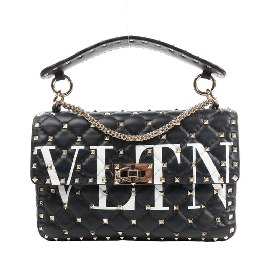 Valentino Garavani VLTN Rockstud Spike 2Way Shoulder Bag in black quilted leather featuring gold-tone pyramid studs, bold white VLTN logo, a gold chain strap, and top handle with stud accents.