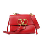 Red Valentino Garavani VRing leather shoulder bag with flap front, oversized gold-tone V logo and ring hardware, and wide leather shoulder strap.