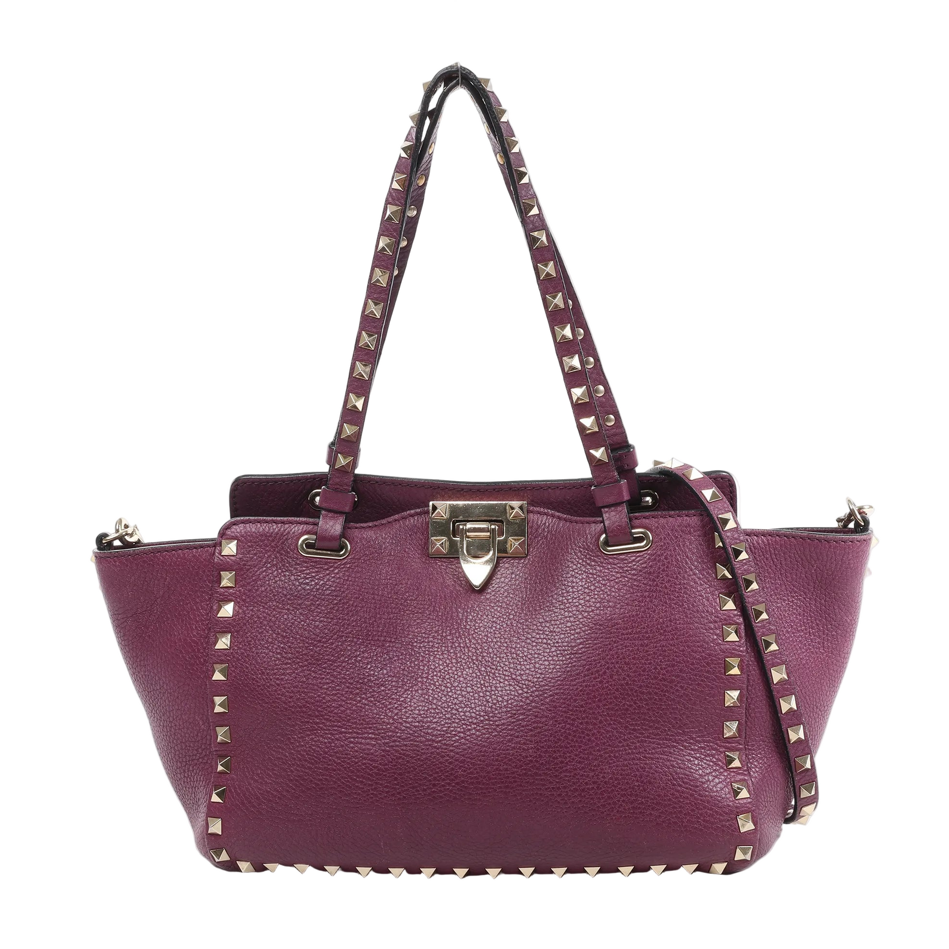 Valentino Garavani Rockstud 2-Way handbag in burgundy grained leather with gold-tone pyramid stud trim, dual top handles, detachable shoulder strap, and clasp closure against a white background.