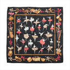 Black Hermès Carré 90 scarf laid flat with red and white ballerinas, musical sheets, pointe shoes and colourful ballet-themed border motifs.