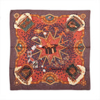 Hermès Carré 90 La Magie silk scarf in brown and red with rabbit in magician’s hat, playing cards, stars, birds and ornate gold motifs.