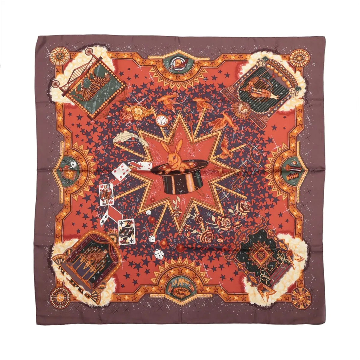 Hermès Carré 90 La Magie silk scarf in brown and red with rabbit in magician’s hat, playing cards, stars, birds and ornate gold motifs.