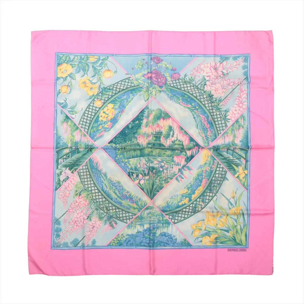 Hermès Carré 90 Giverny silk scarf with bright pink border, blue-green garden scene, floral motifs and decorative bridge design.