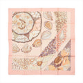 Pink square scarf with detailed seashell illustrations, layered shell strands and peach, cream and brown accents on a pale pink background.