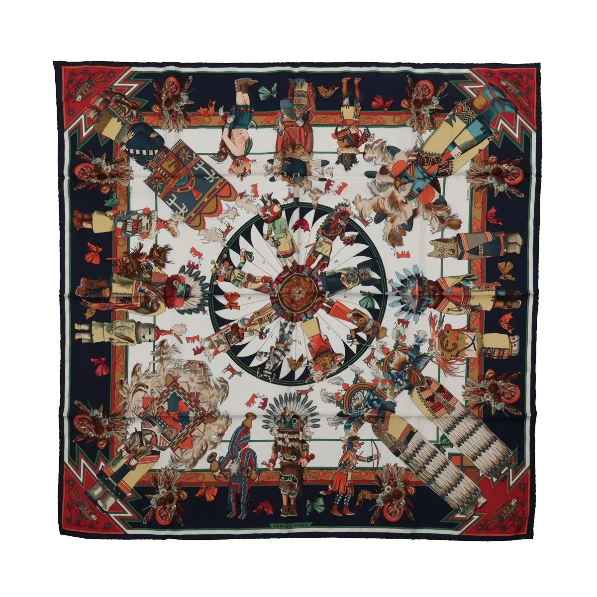 Hermès Kachinas silk scarf with navy blue border, colorful ceremonial figures, feathered headdresses and red, green and cream geometric motifs.