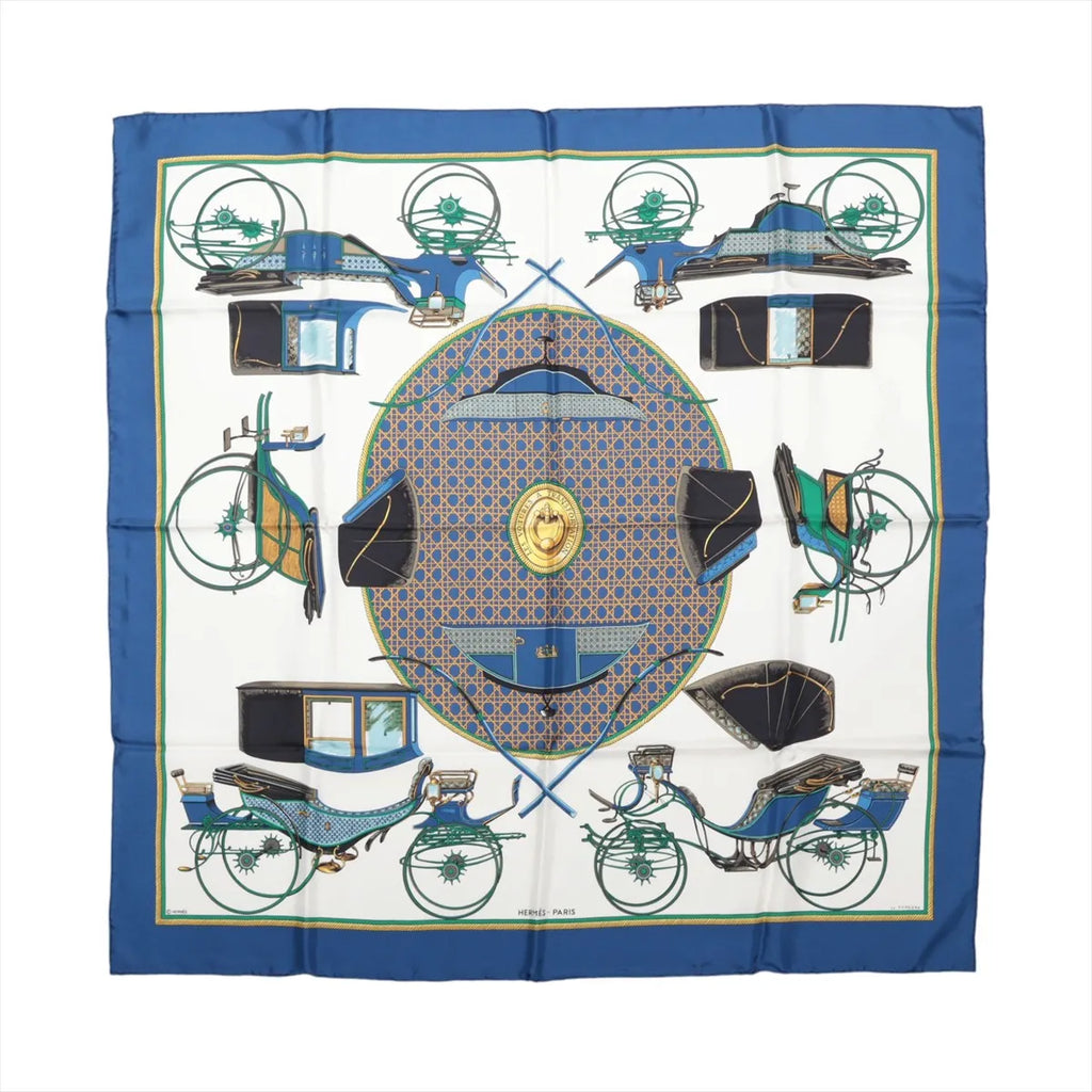 Hermès Les Voitures à Transformation silk scarf with blue border, ivory center and illustrated carriages in blue, green, black and gold.