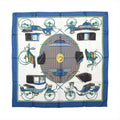Hermès Les Voitures à Transformation silk scarf with blue border, ivory center and illustrated carriages in blue, green, black and gold.