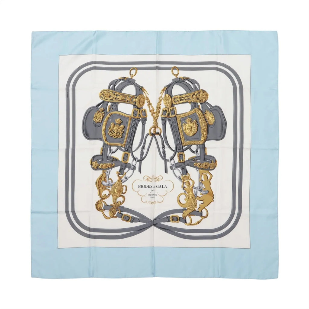 Hermès Brides de Gala silk scarf with light blue border, ivory center, gray equestrian bridles and ornate gold hardware details.