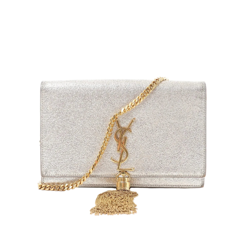 Saint Laurent Kate Small crossbody bag in metallic glitter gold with gold-tone YSL monogram, gold chain strap and tassel detail on white background.